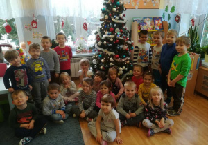 Grupowe zdjęcie z ubranym świątecznym drzewkiem.